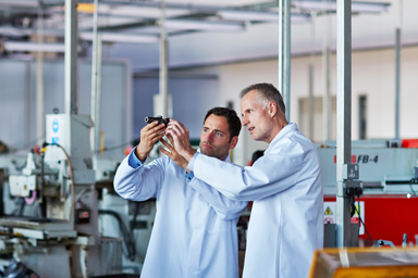 Two researchers study an object.