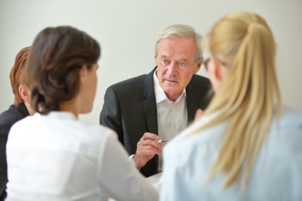 Ein über 60-jähriger Mann bei einem Arbeitstreffen.