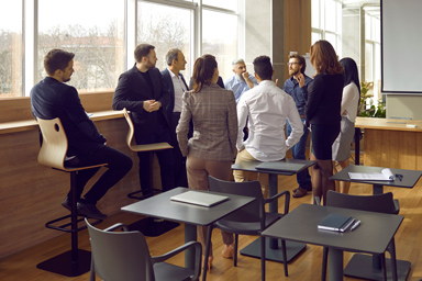 Mehrere Beschäftigte unterhalten sich in einem Meetingraum.