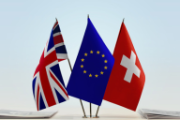 Die europäische, die britische und die Schweizer Flagge sind auf einem Tisch aufgestellt.