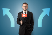 Ein junger Mann im Anzug hält eine Schweizerfahne in der Hand und lächelt.