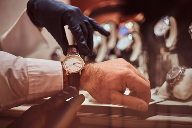 Ein Mann probiert eine Uhr an seinem Handgelenk an.