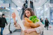 Eine Frau mit einem langen Kassenbon in einem Supermarkt.