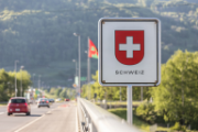 Ein Schild am Strassenrand mit dem Schweizerwappen und der Aufschrift "Schweiz".