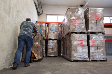 A man pushing goods on a pallet.