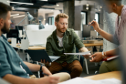 Three employees talking in an open space.