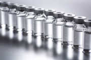 Ten medical vials with transparent fluid.
