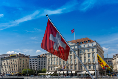 View of the Quai des Bergues in Geneva, with its hotels and flags.