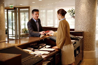 A man gives a document to a receptionist