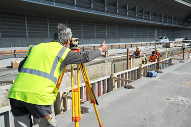 A person taking measurements at a construction site.