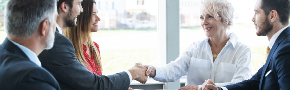 A man and a woman shake hands during a (work) meeting