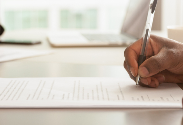 A man fills a document with a pen 