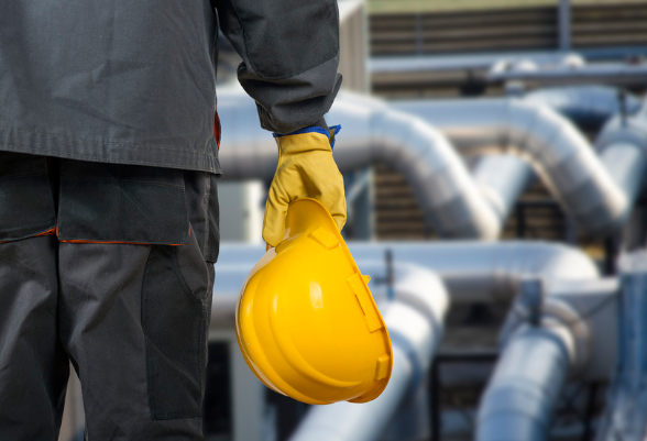 A man holds a construction helmet in his right hand