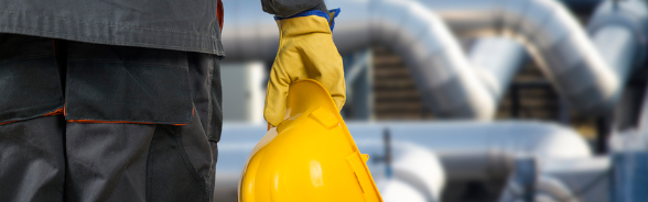 A man holds a construction helmet in his right hand