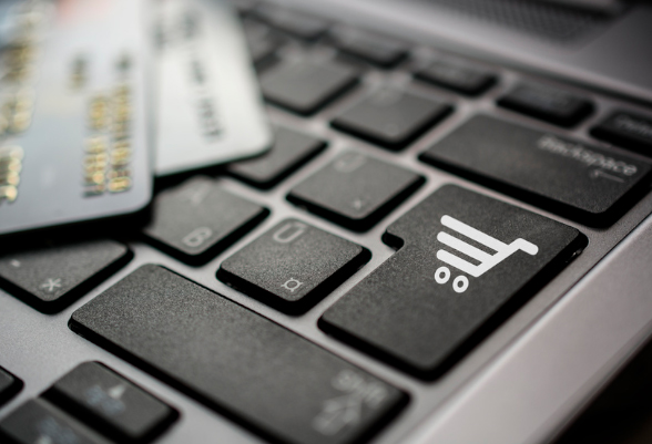 Close-up of a computer keyboard key with a shopping cart on it.