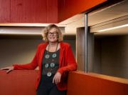 A person wearing a helmet, goggles and using a computer works on an electrical panel
