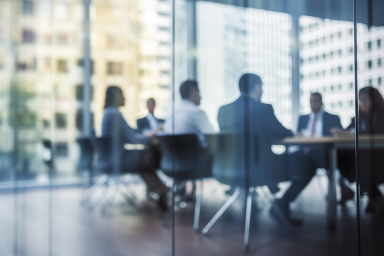 People in a meeting behind a glass window