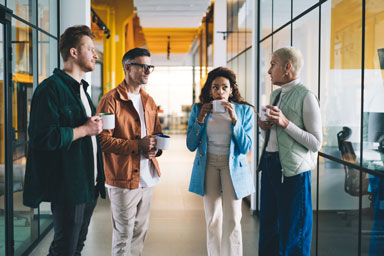 Four people conversing in a professional space.