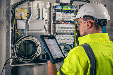 A man in front of an electrical panel.