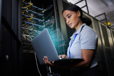 A woman with a computer in a data centre