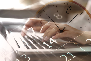 A watch, figures, and a person typing on a computer keyboard