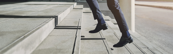 A man in a suit climbing stairs.