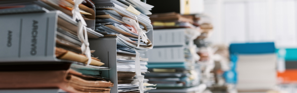 Filing cabinets and documents stacked in an office