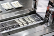 Des gélules de médicaments sont empaquetées sur une chaîne de production.