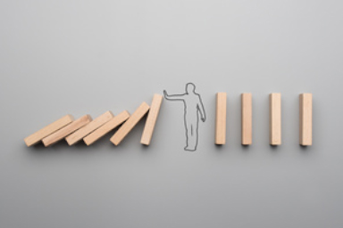 Des dominos tiennent debout grâce à un personnage dessiné au centre.