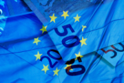 Une image du drapeau de l’Union Européenne est superposée à des billets de banque en euros.