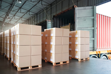 Des cartons empilés dans un hangar.