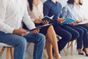 Plusieurs personnes assises en rang dans un contexte professionnel.