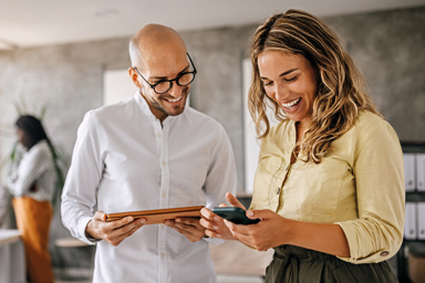 Un homme et une femme consultent un portable et une tablette.