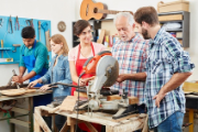 Un luthier organise enseigne son métier à un groupe d'intéressés dans son atelier. 