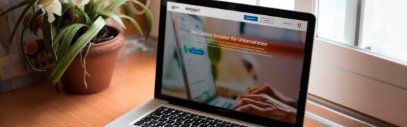 Un ordinateur portable est posé sur un bureau. Son écran affiche le site EasyGov.swiss.