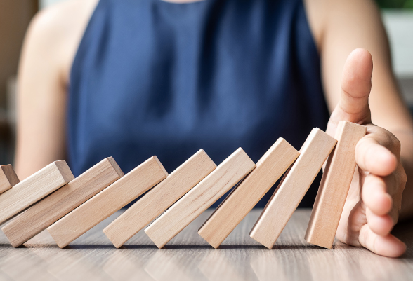 Une femme retient un jeu de domino avec sa main.