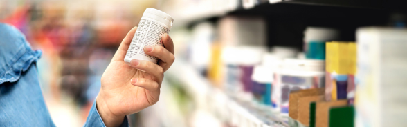 Un consommateur prend une boîte de médicaments dans un magasin.