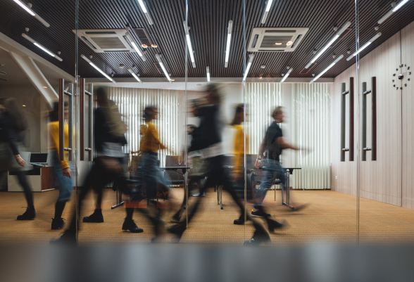 Des hommes et des femmes se déplacent dans un bureau.