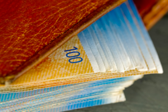 Delle banconote da 100 franchi svizzeri fuoriescono da un portafoglio.