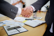due uomini in completo da lavoro si stringono la mano