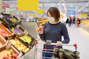 Una donna con mascherina fa la spesa in un supermercato. 