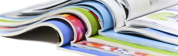 Alcune riviste colorate sono posate aperte a metà l'una sull'altra.