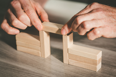 Una persona impila piccoli rettangoli di legno.